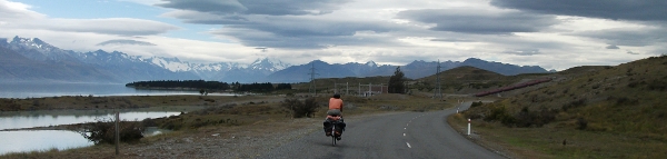 Guy Cycling Along Lake Pukaki with Mt Cook in the distance